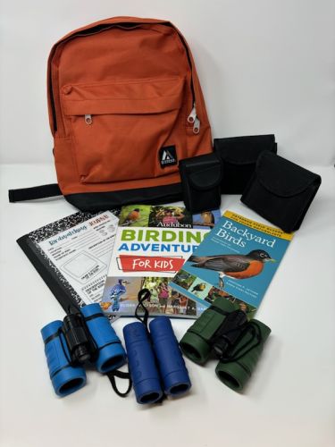 "Budding birders pack on white background with books and binoculars"